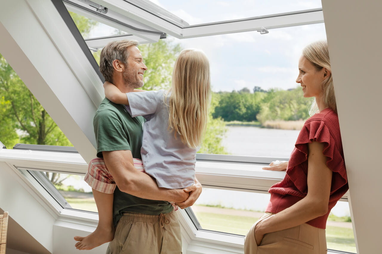Family standing by the open roof window enjoying daylight and fresh air
