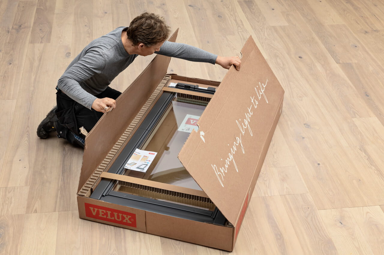 Person opening a box with VELUX roof window inside