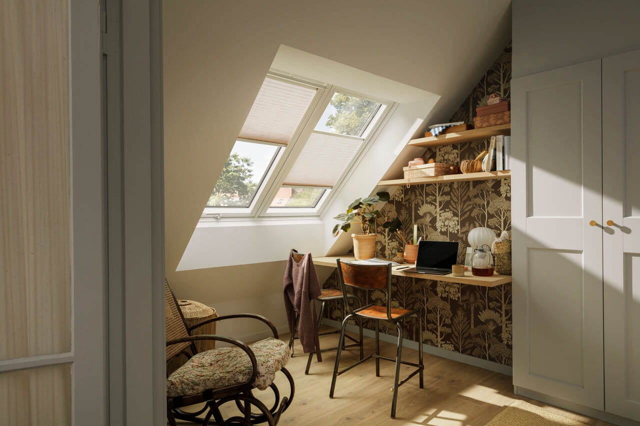 Home office area in the attic with roof windows and blinds