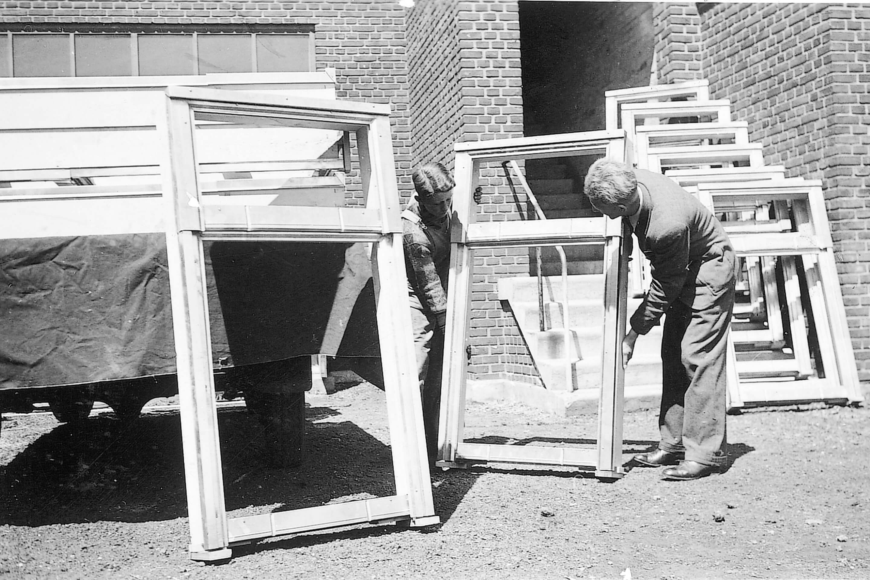 Two men carrying VELUX roof window for transportation