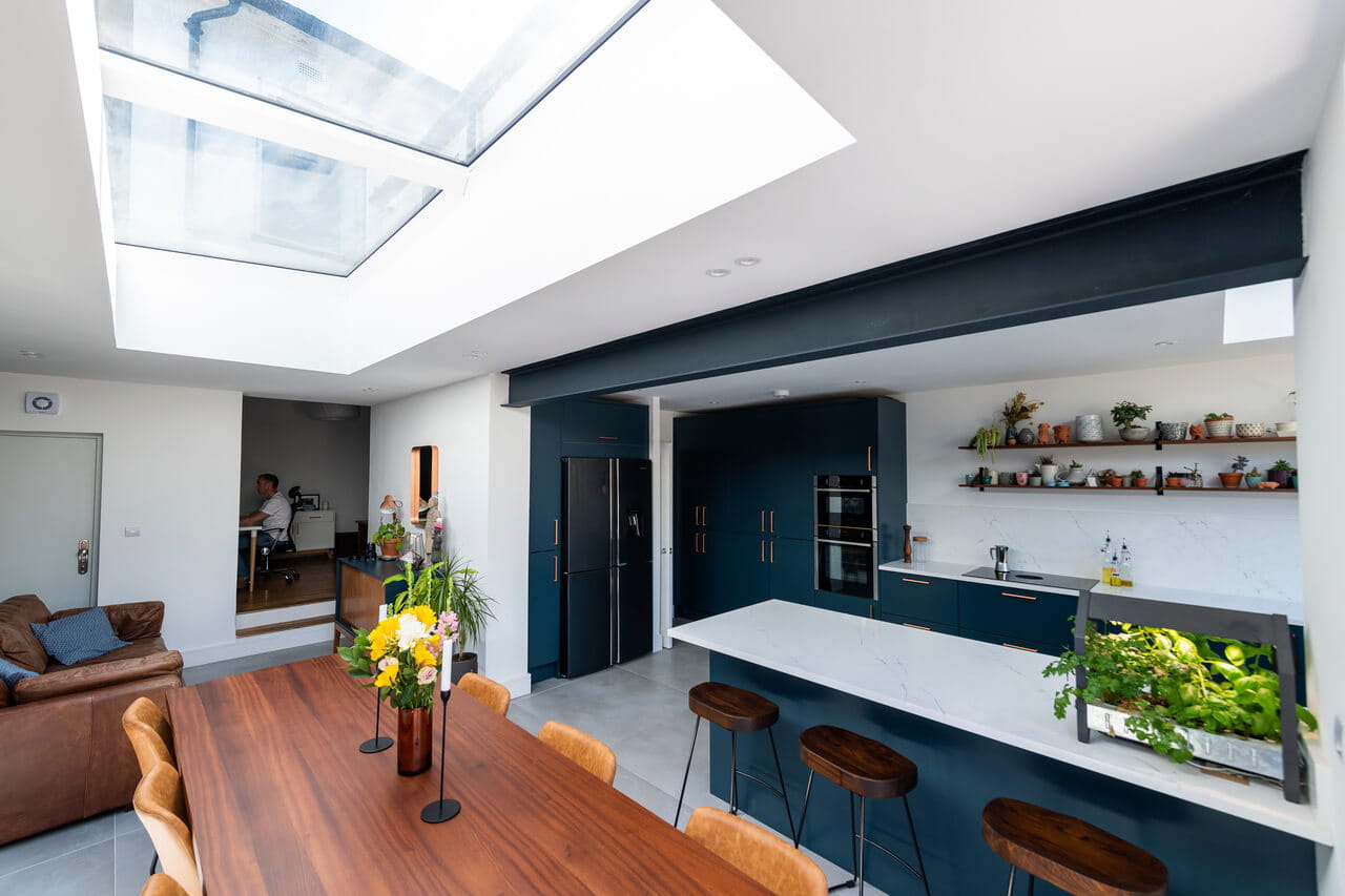 A very bright kitchen and dining room area with flat roof windows