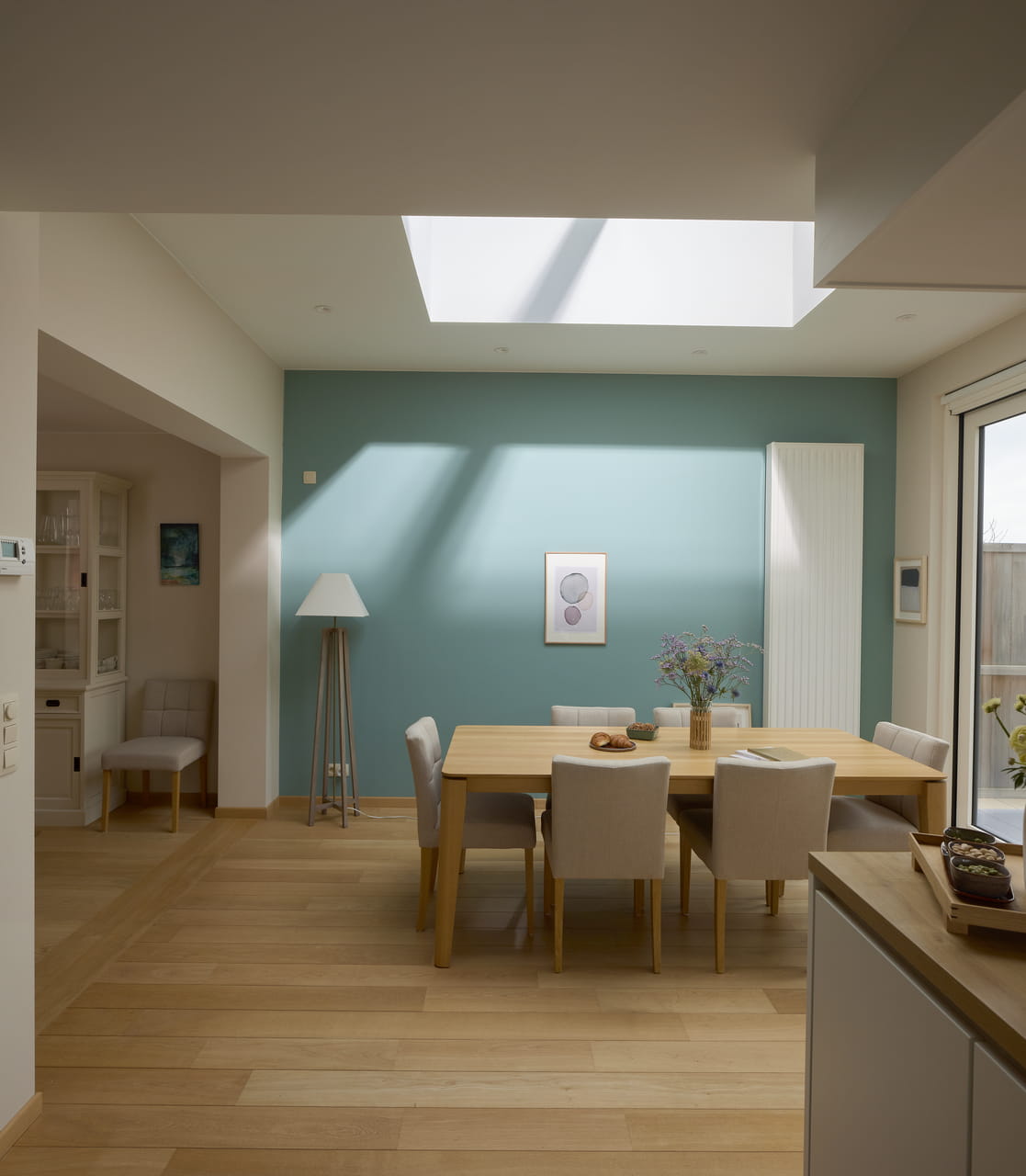 A modern kitchen and dining room with a big flat roof windows