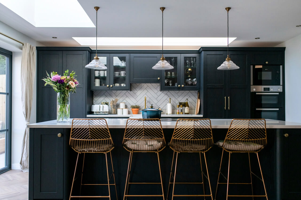 "A modern kitchen with dark painted cabinets and flat roof windows