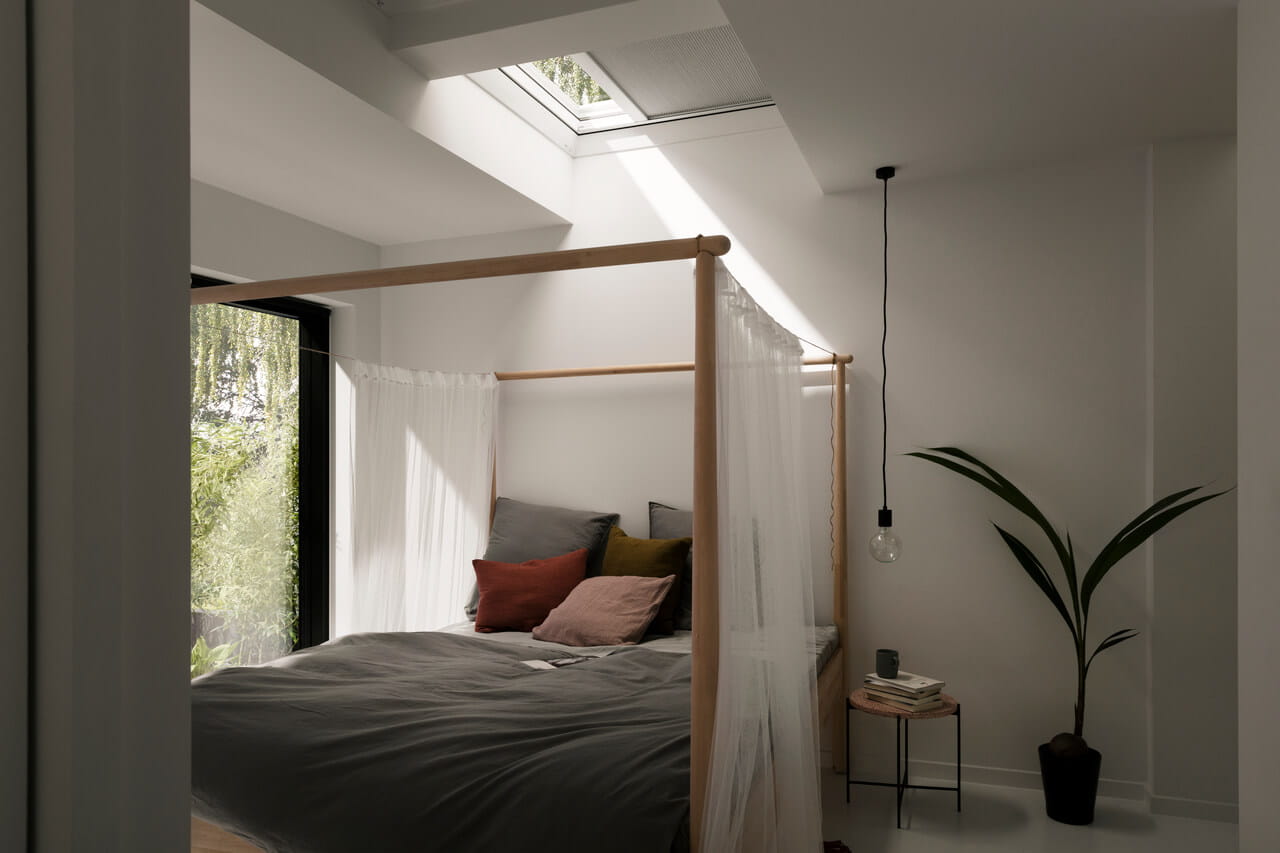 Bedroom with a flat roof window above bed