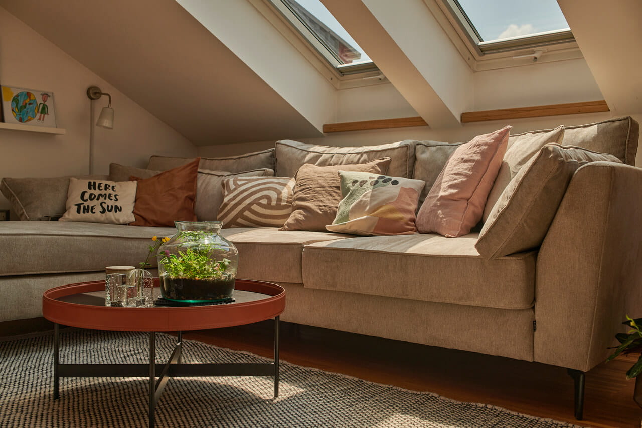A lining room area with corner sofa and two roof windows above it.