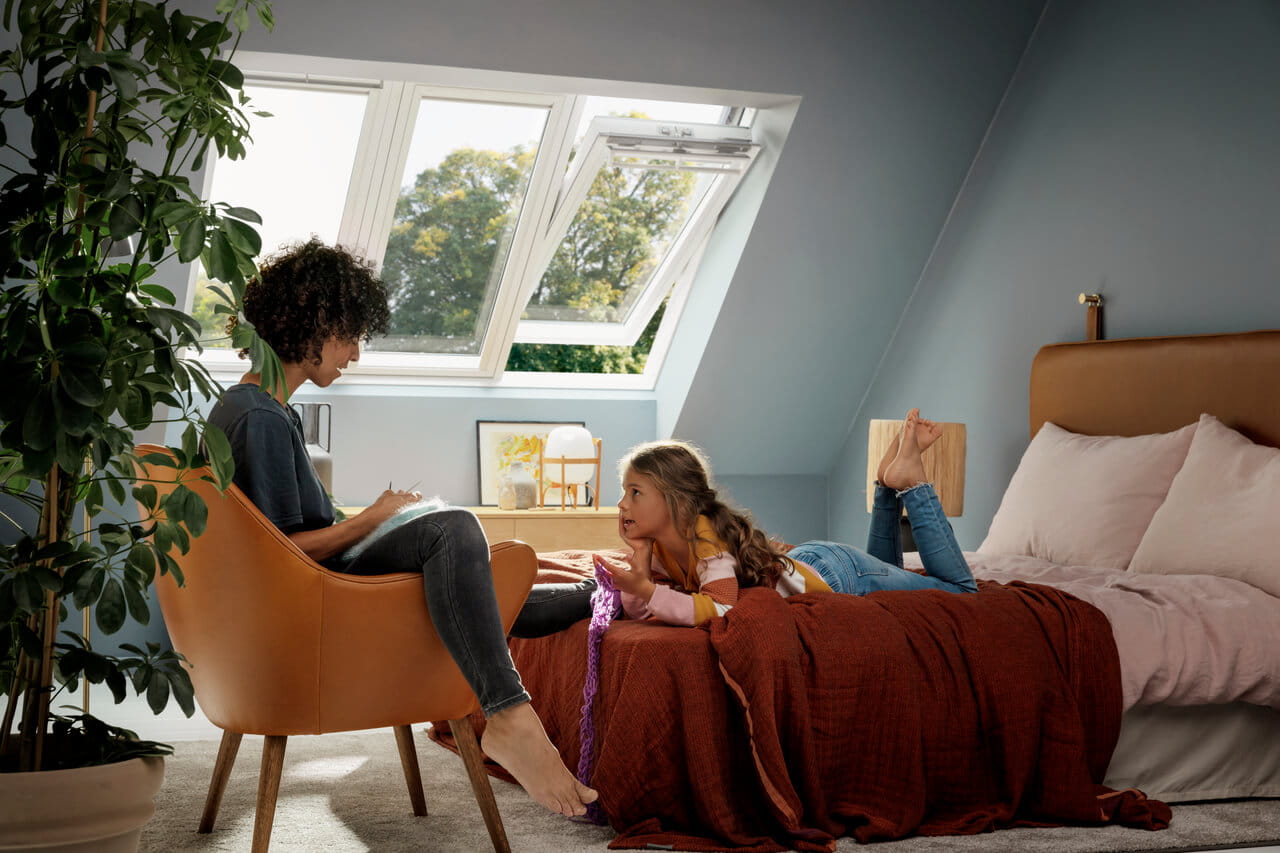 Woman and girl in the bedroom with 3in1 VELUX roof windows