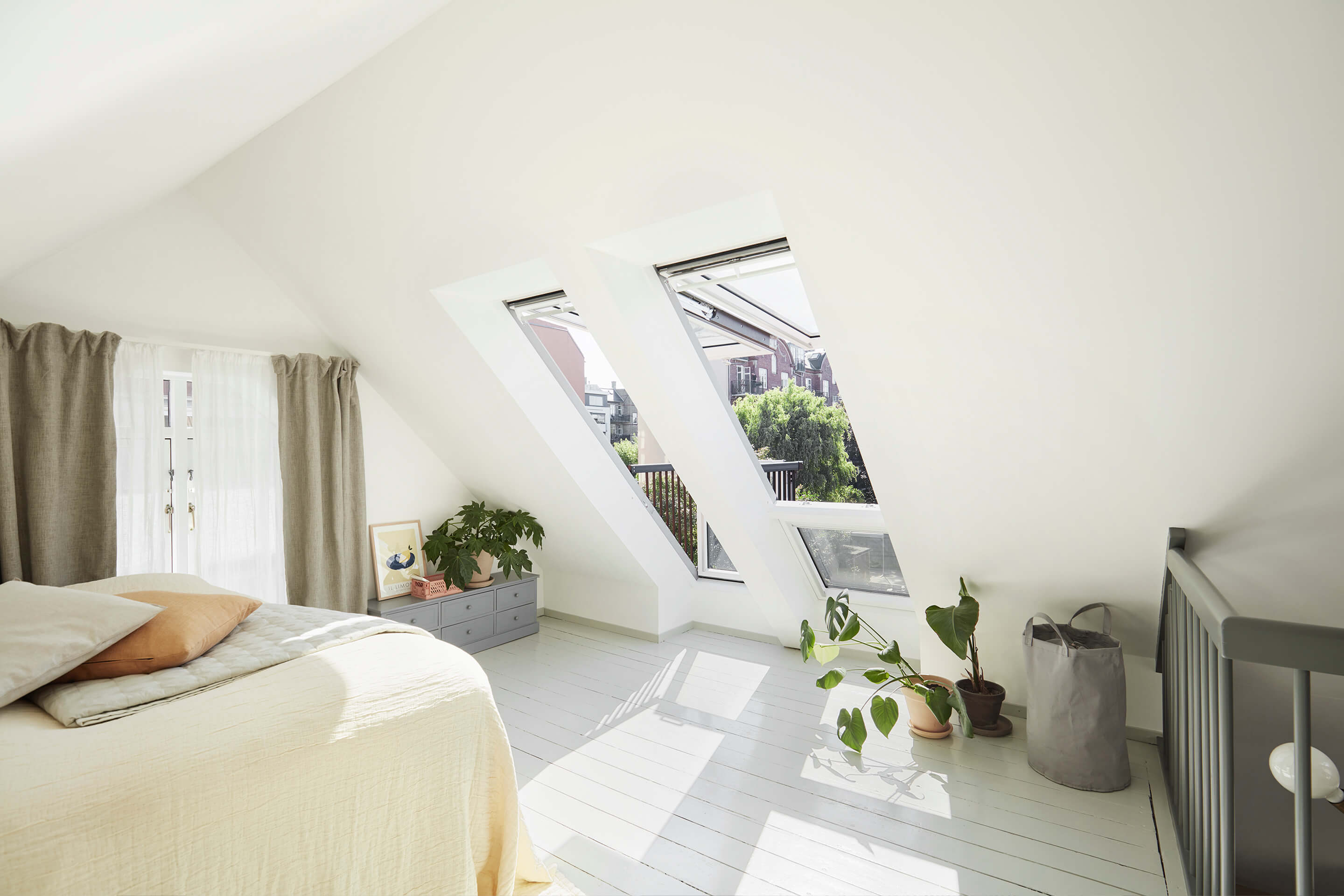 A bright bedroom with open roof windows.