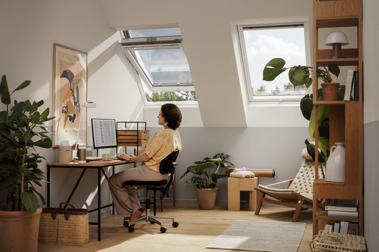 Woman sitting in home office with VELUX roof windows