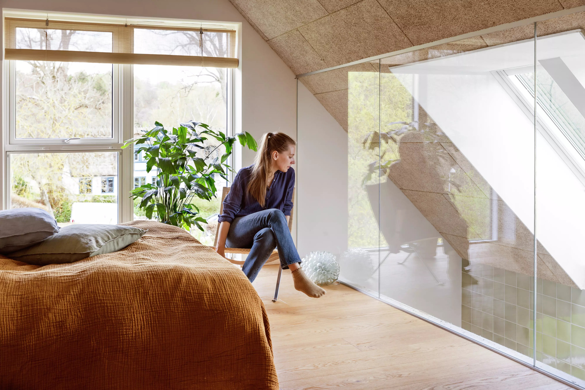 Woman sitting in her room with VELUX roof windows