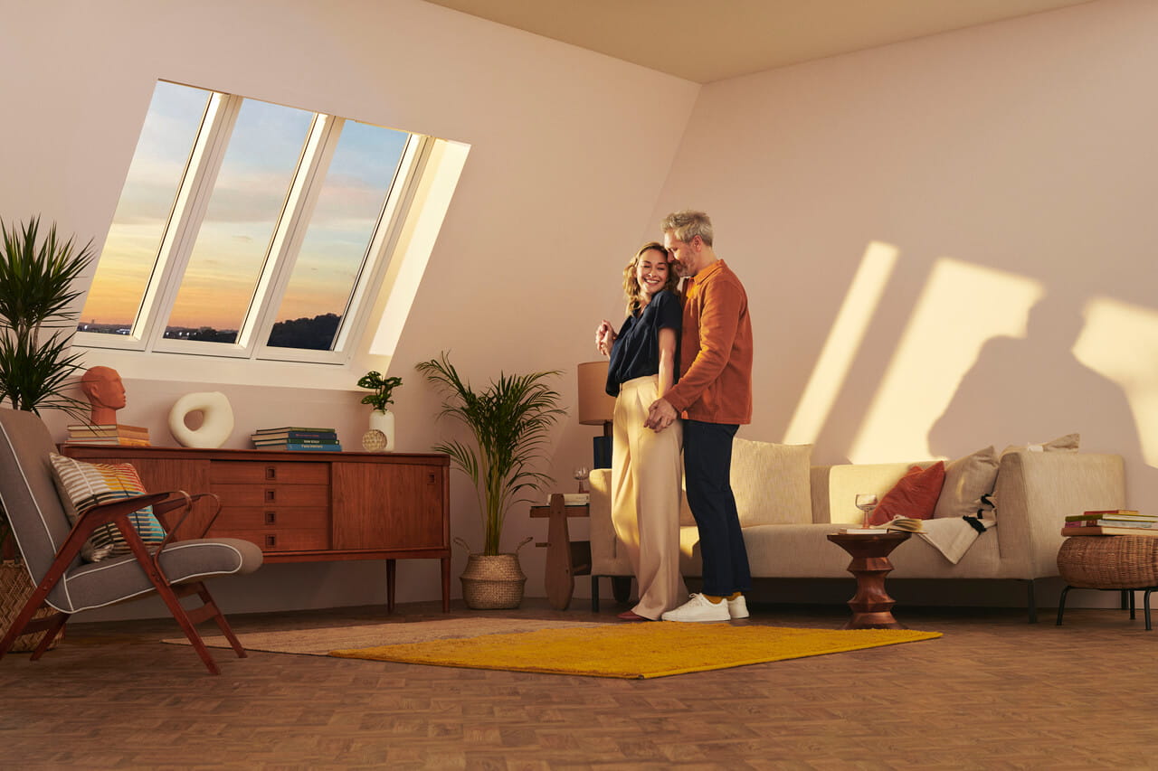 Man and woman standing in the middle of living room.