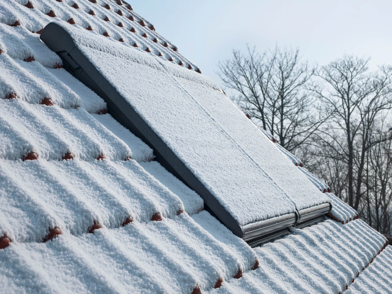 Roof image in winter with snow covering tiles and roof windows shutters