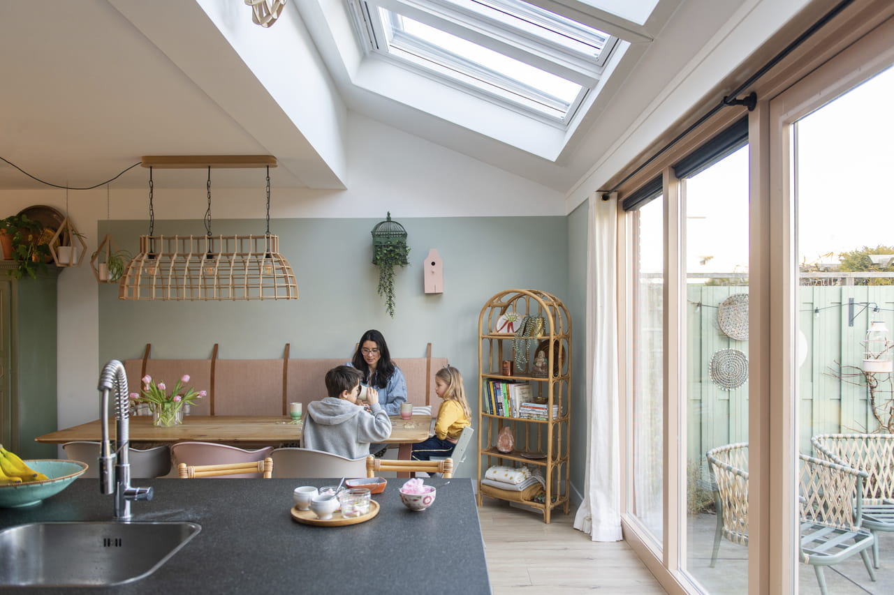 Family in bright kitchen with VELUX 3in1 roof windows
