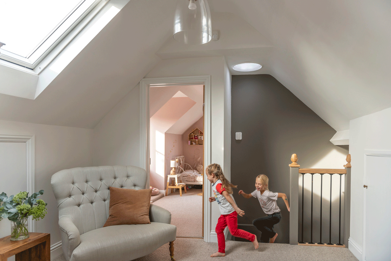 Stylish and bright bedroom in the attic with a 3in1 roof window from VELUX
