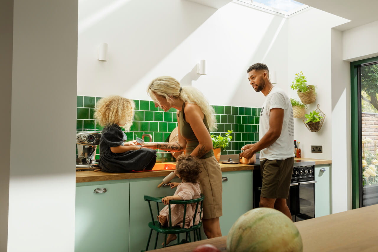 Family cooking in the green painted kitchen