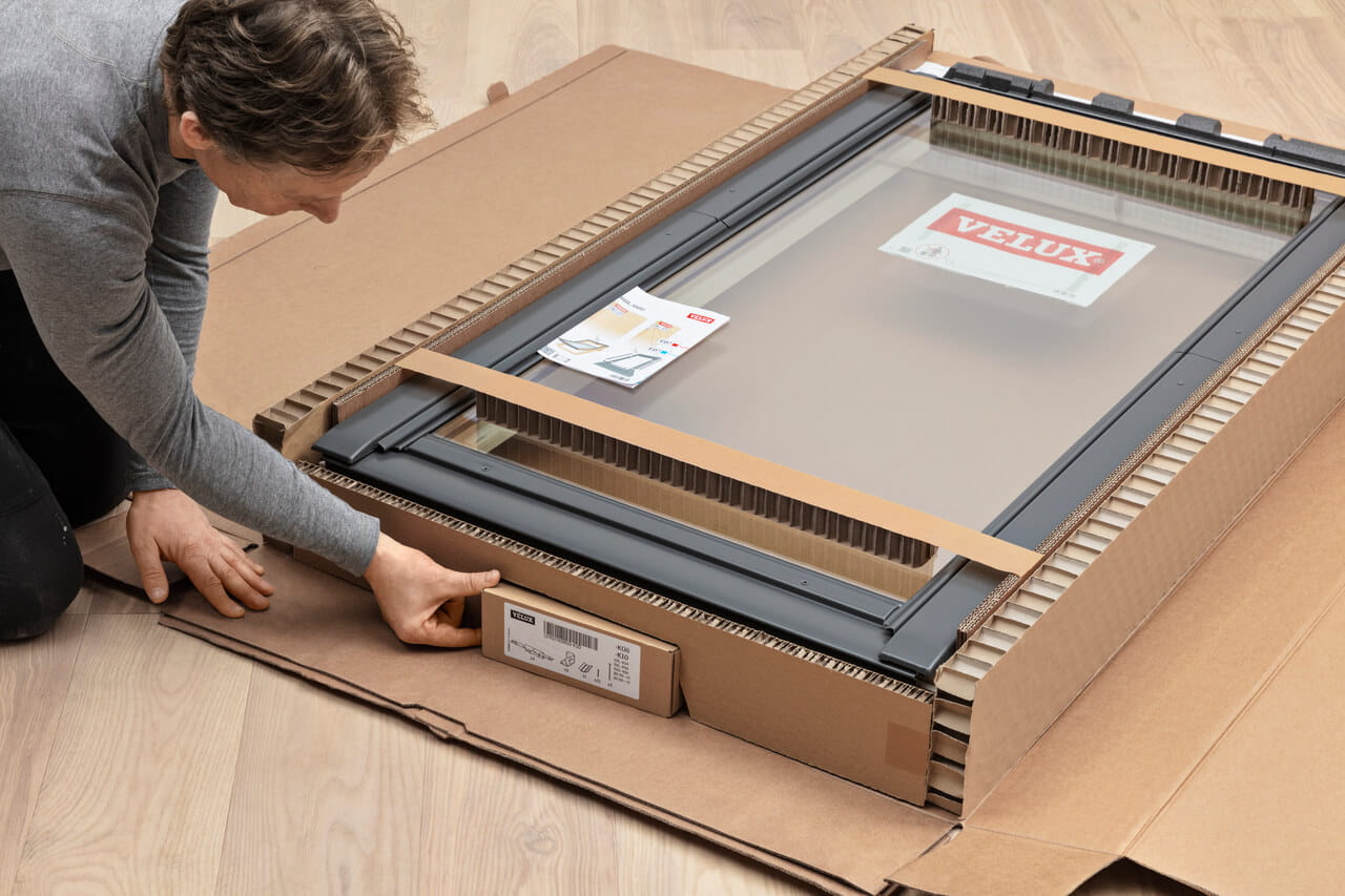 Man opening a carton VELUX roof window packaging