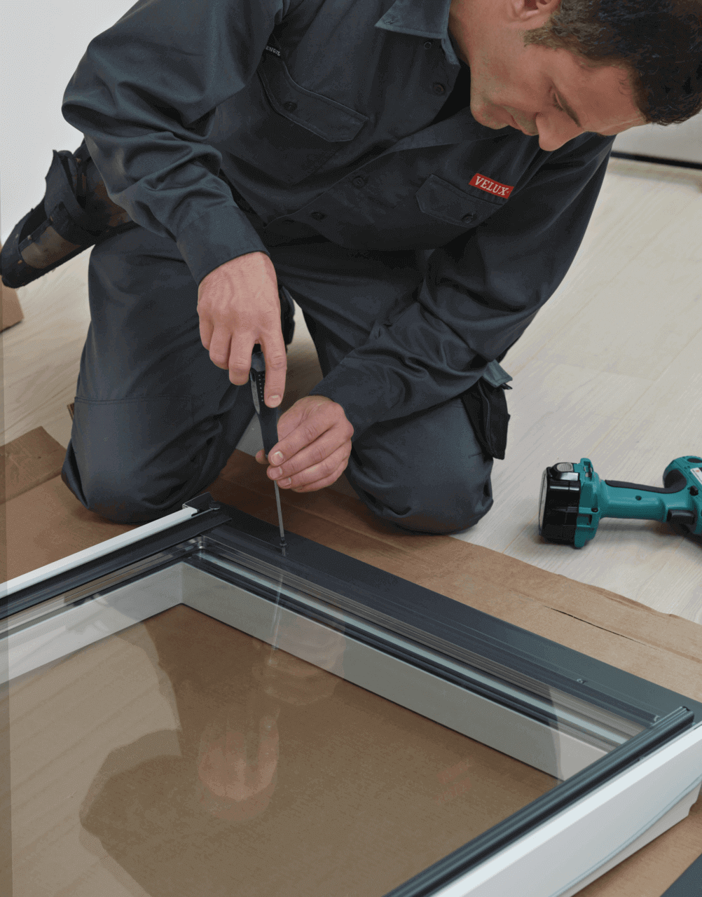 Man putting the screw in the frame of roof window