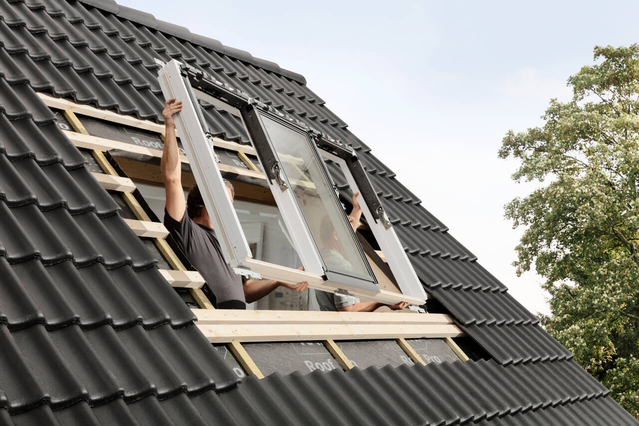 Two men install a VELUX 3-in-1 roof window
