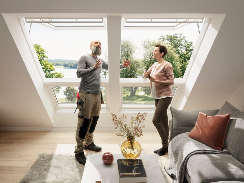Installer is showing features of VELUX roof windows to a woman.