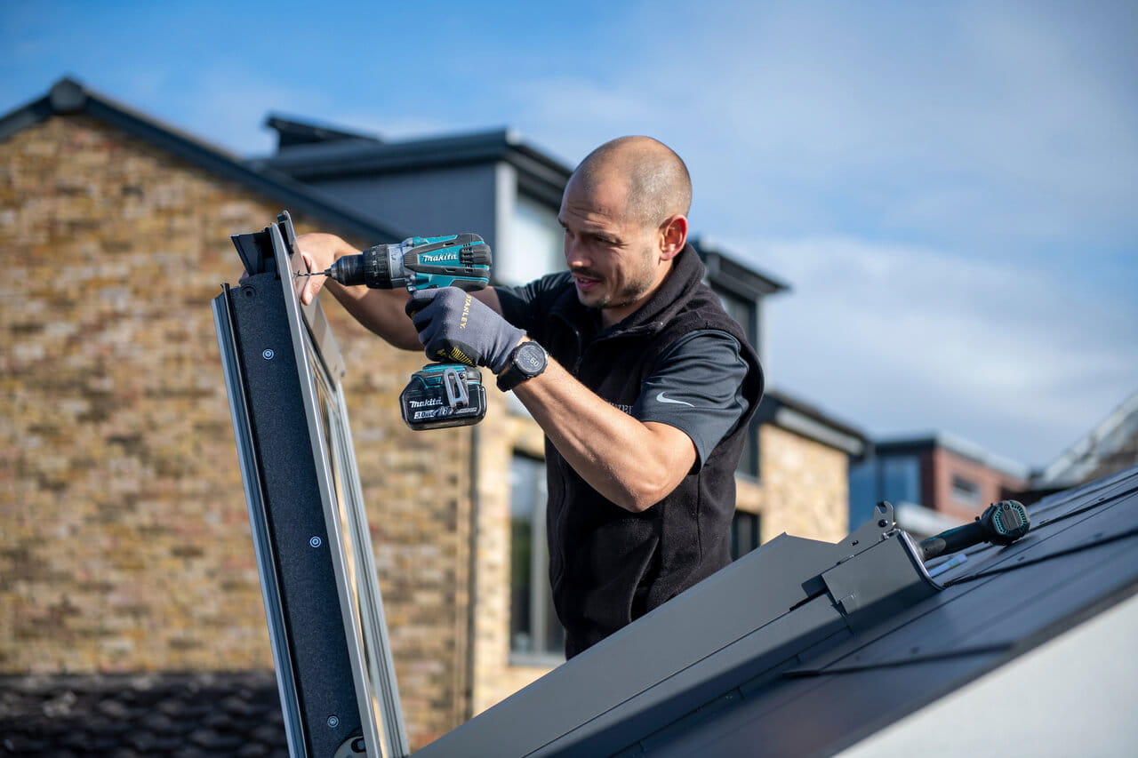Installer drilling roof window.