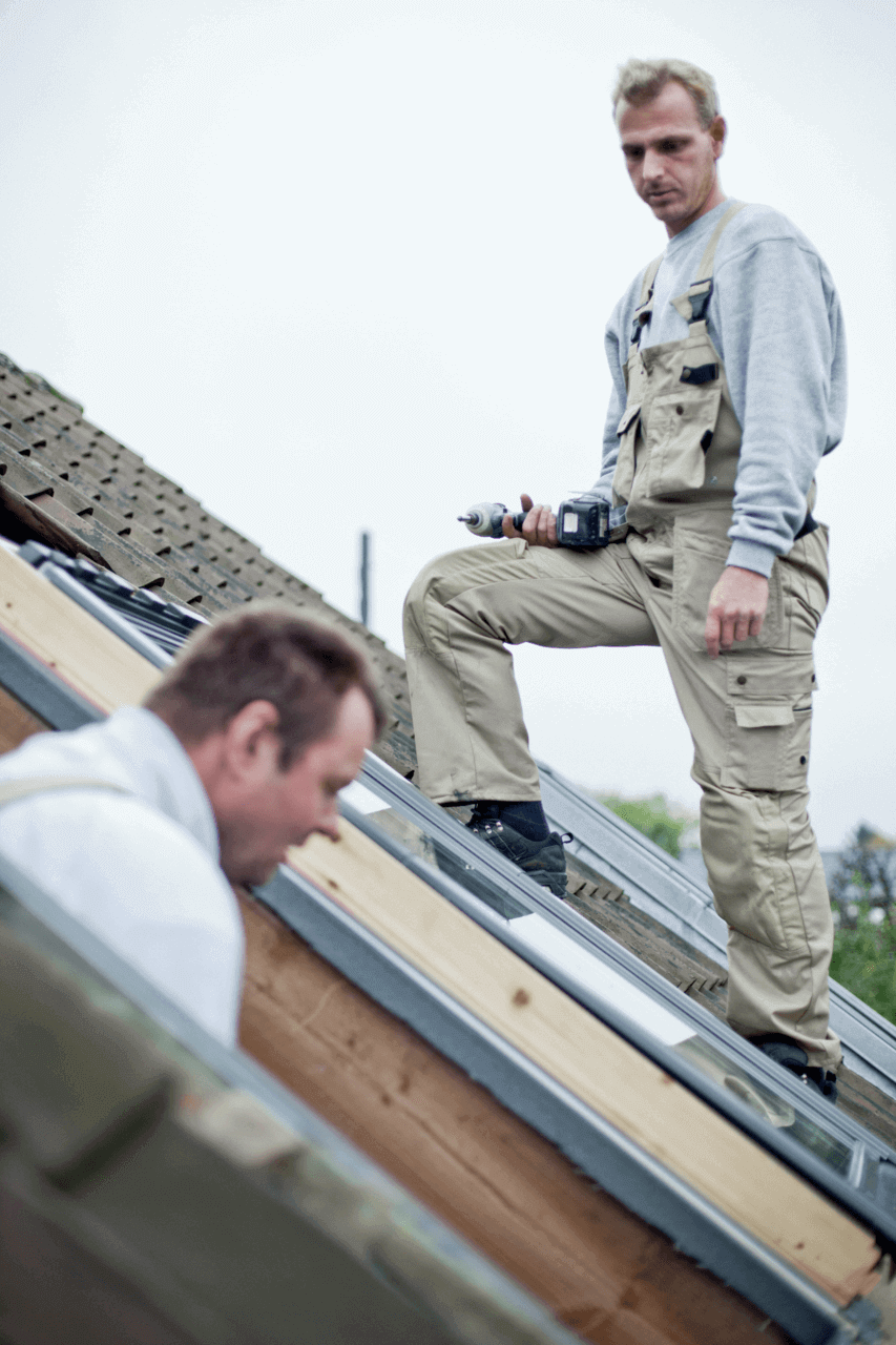 Two men on the roof installing roof windows