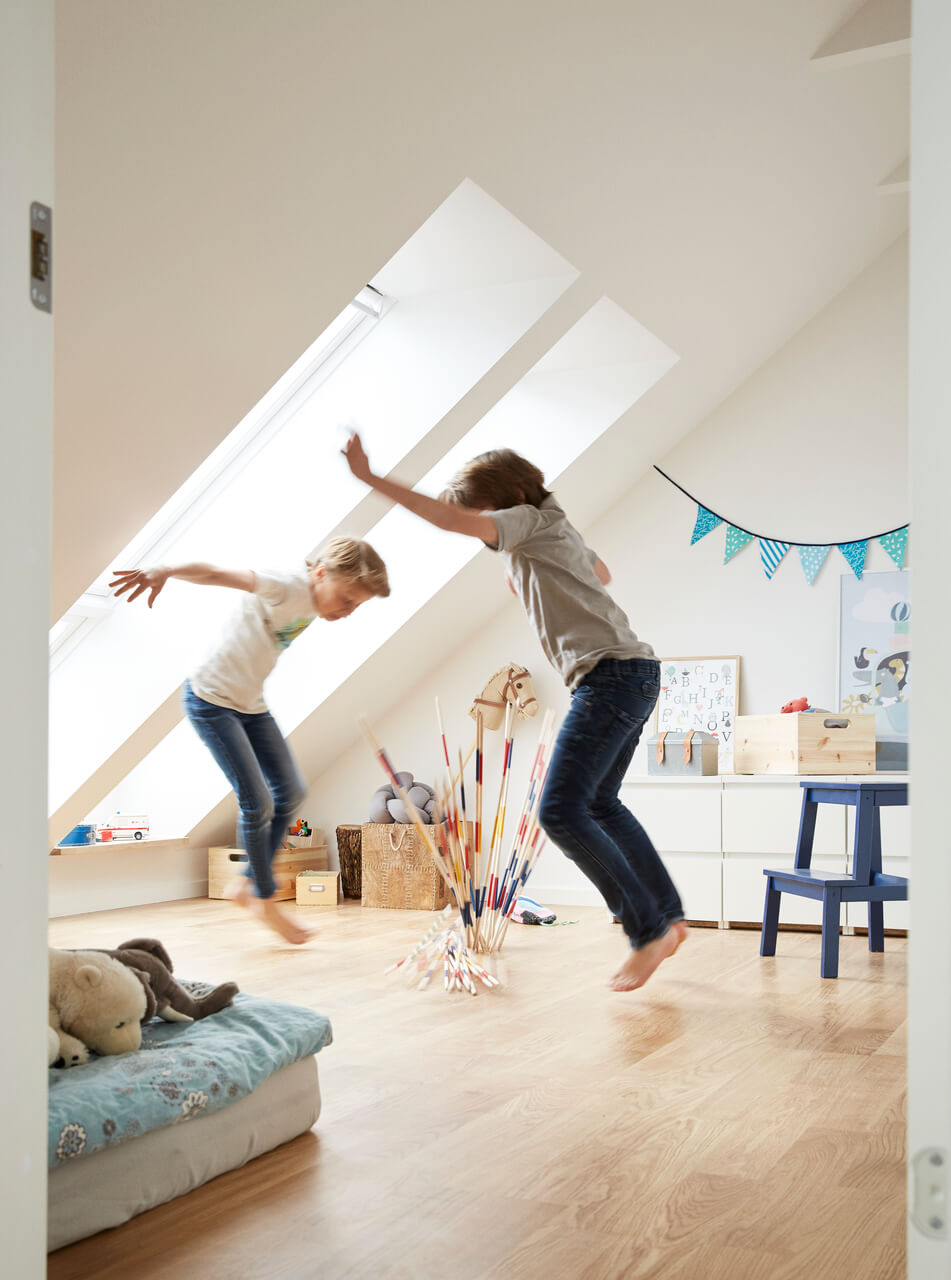 Two kids jumping on the floor.
