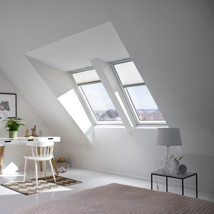 A bright home office in the attic with mini dormer roof windows.