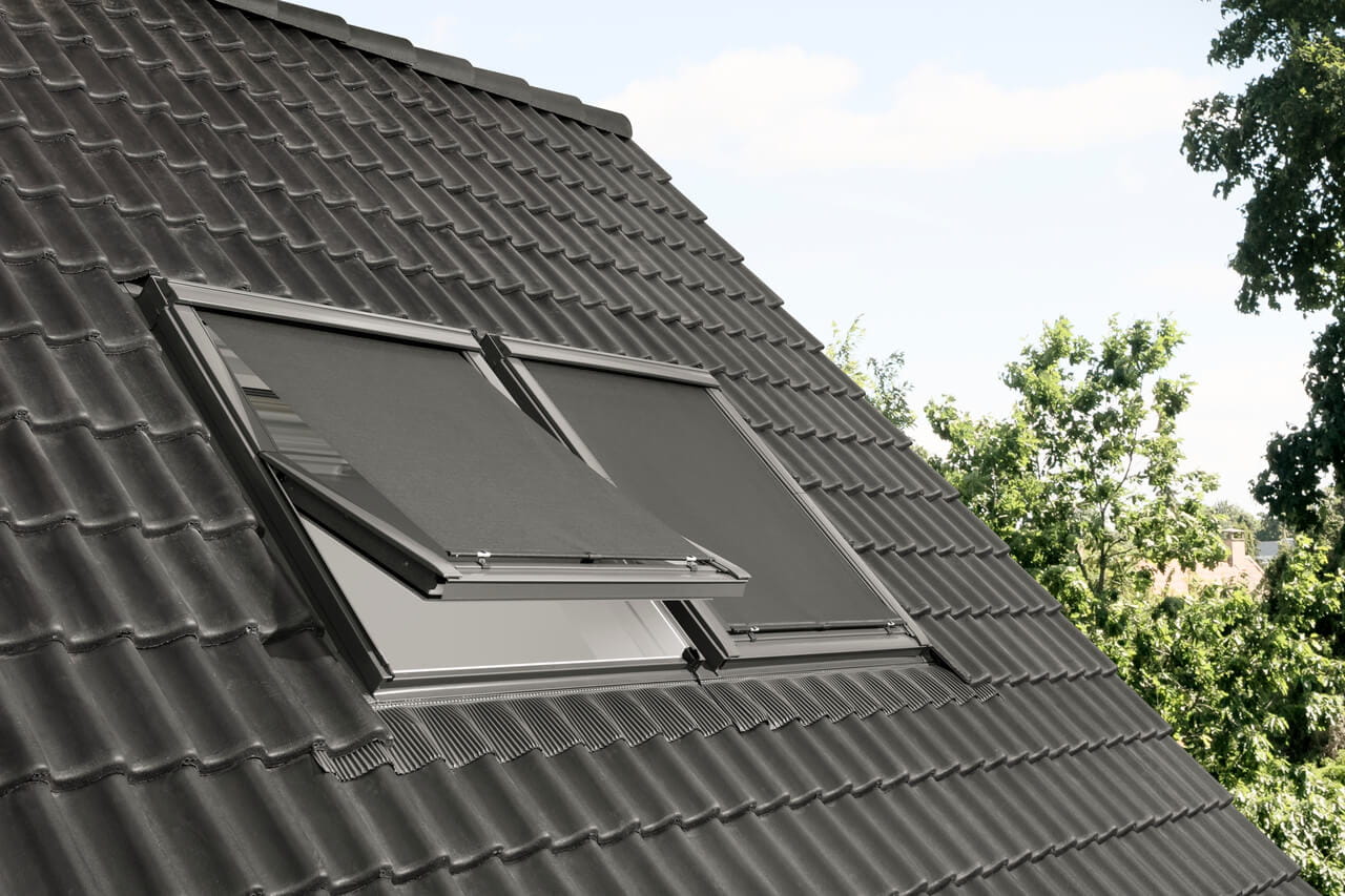 Exterior image of a roof with 2 VELUX roof windows and anti-heat blinds installed.