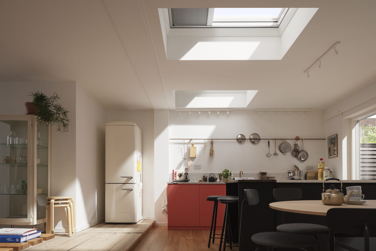 Kitchen and dining area with VELUX flat roof windows and blackout blinds partially drawn.