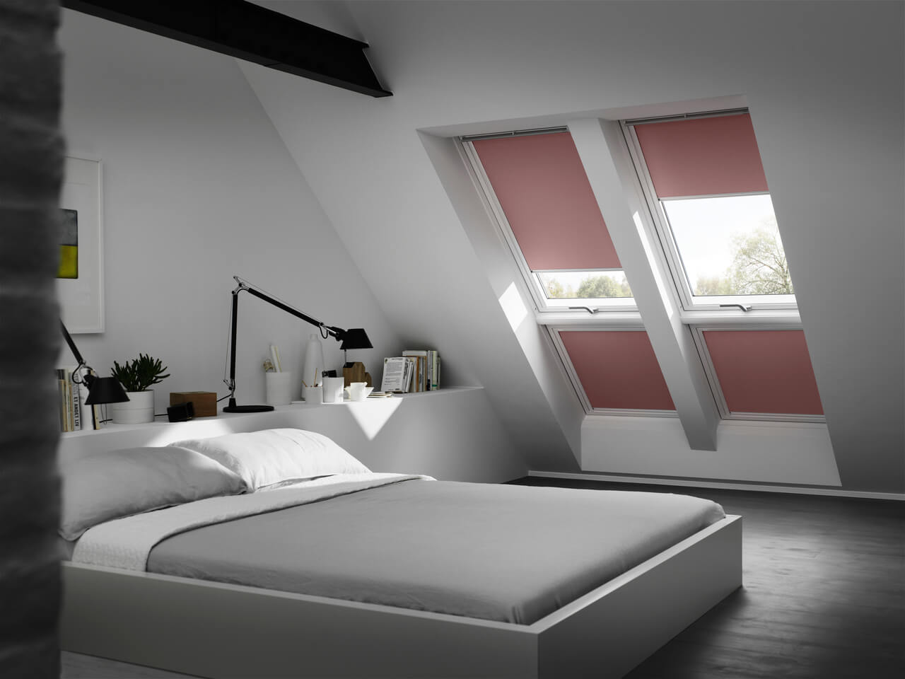 Bedroom image with pink VELUX blackout blinds installed in 4 windows.