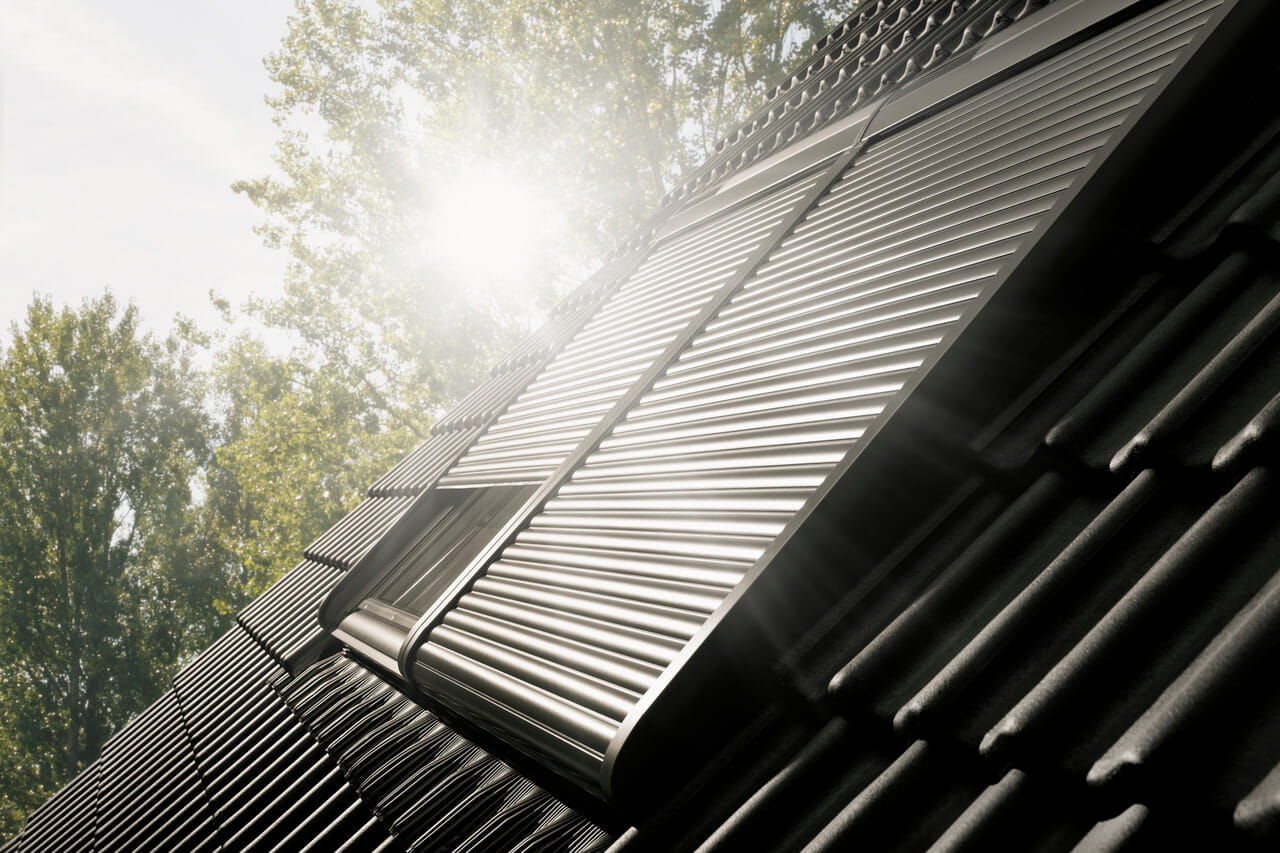 Exterior image of VELUX roller shutters, one partially opened.