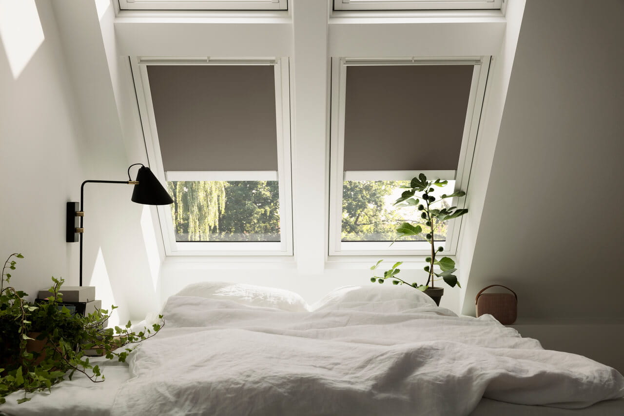 Image of 2 VELUX windows with blackout blinds to block out light in a bedroom.