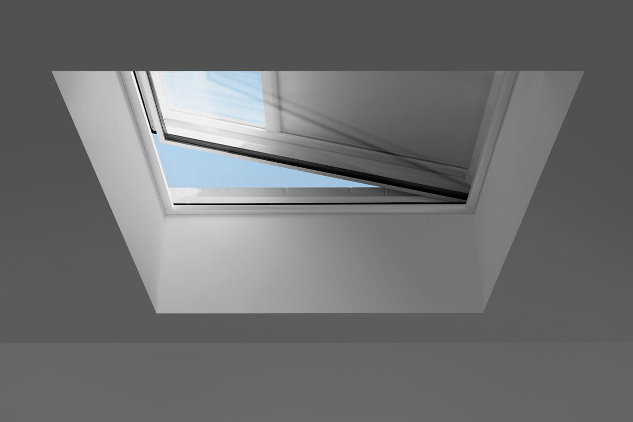 Interior image of a VELUX flat roof window with an inset-screen and anti-heat blind installed.