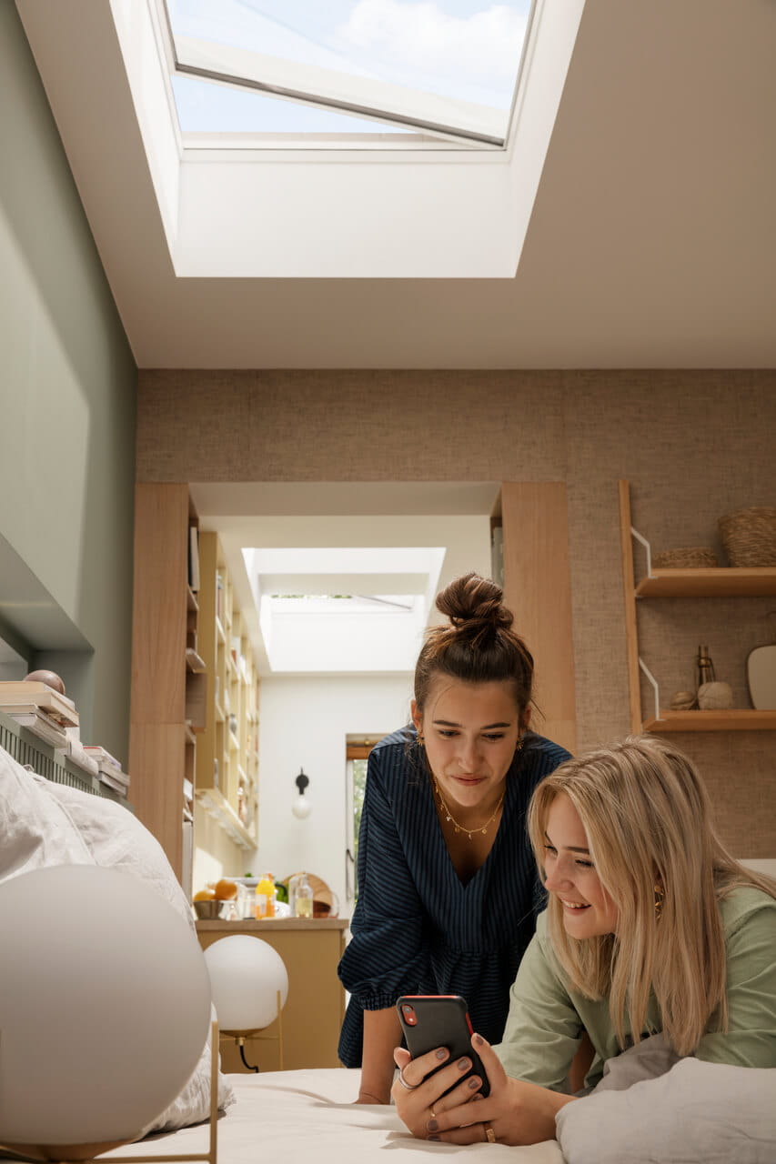 Two teenagers under a VELUX Curved glass rooflight