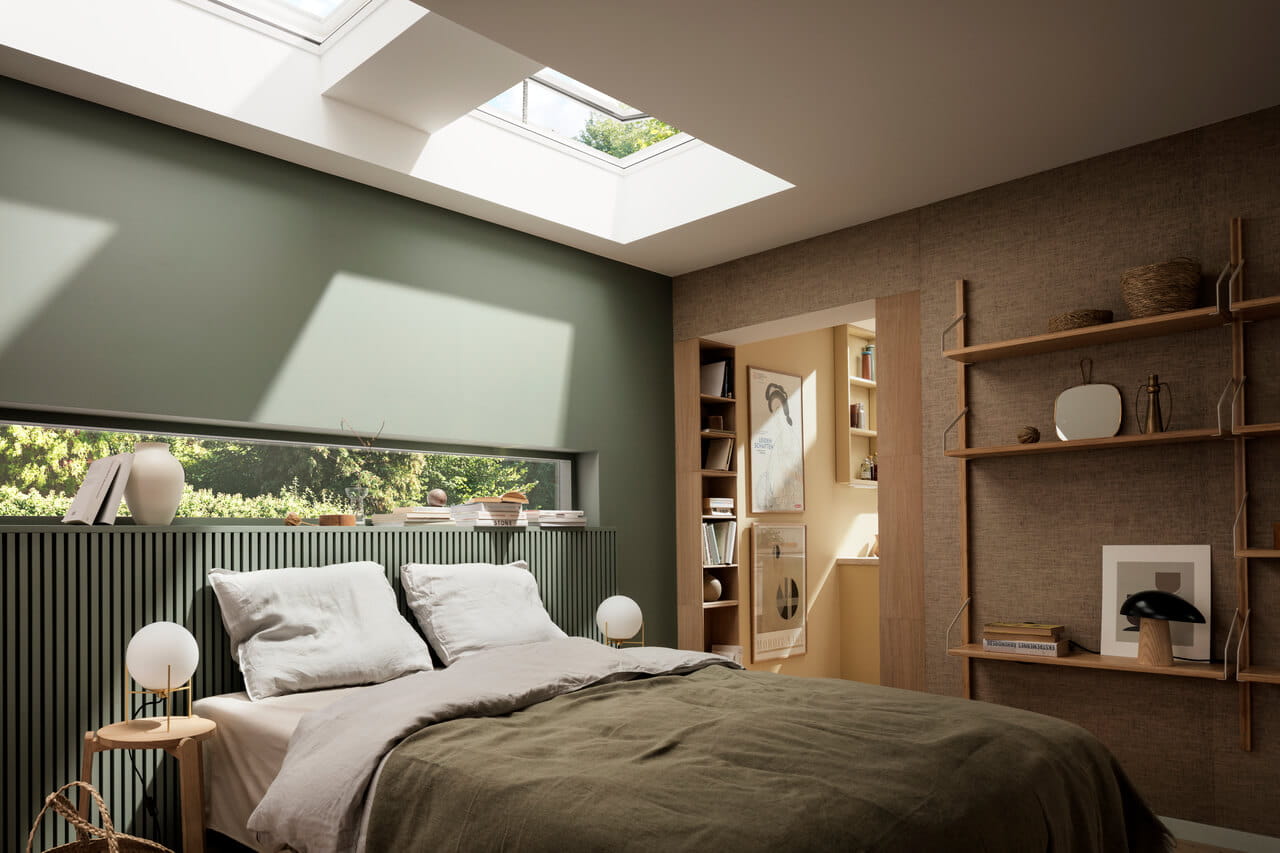 Bedroom with green wall and bedsheets, and VELUX flat glass rooflights installed over the bed