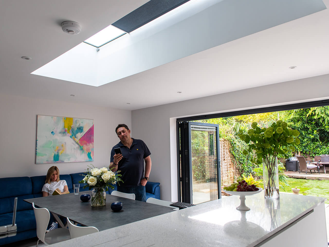 Man operating roller blind connected to Vario flat rooflight