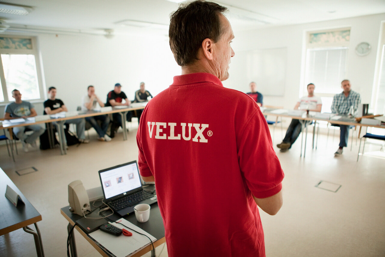 A man with VELUX shirt standing in front of group people
