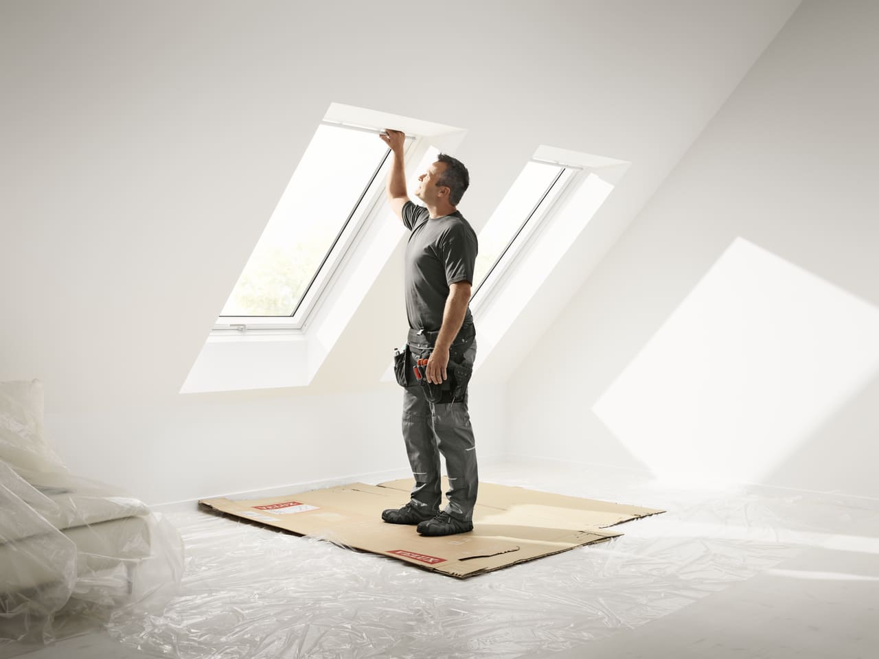 Roofer checking the installation of a new VELUX roof window viewed from the inside