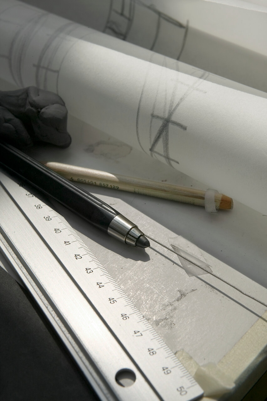 A section of technical drawing on a paper and some drawing items