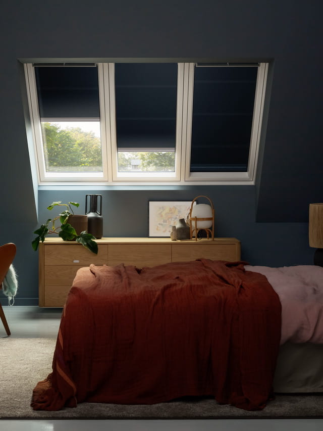 Bedroom with dimming blinds on a roof window from VELUX