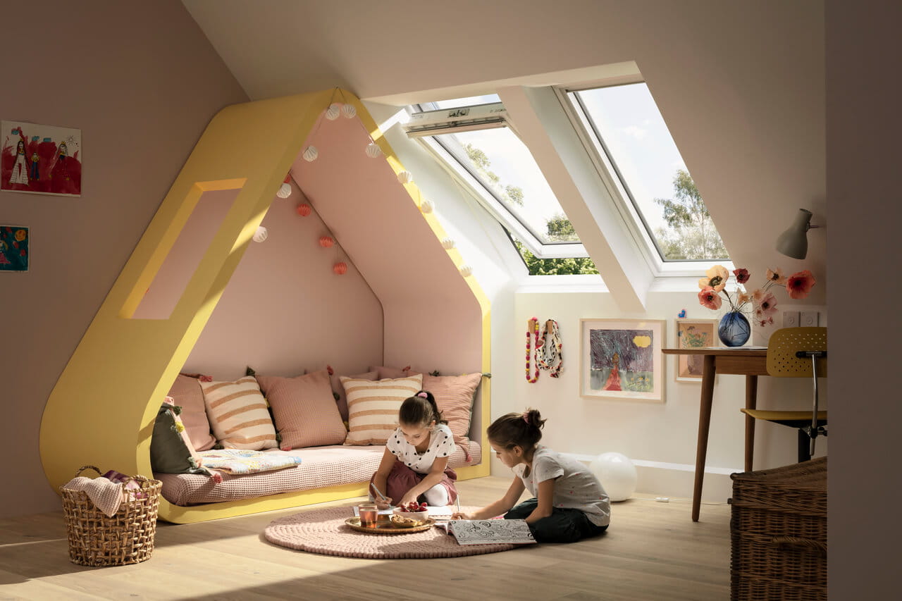 A colourful kids room with two girls paying on the ground