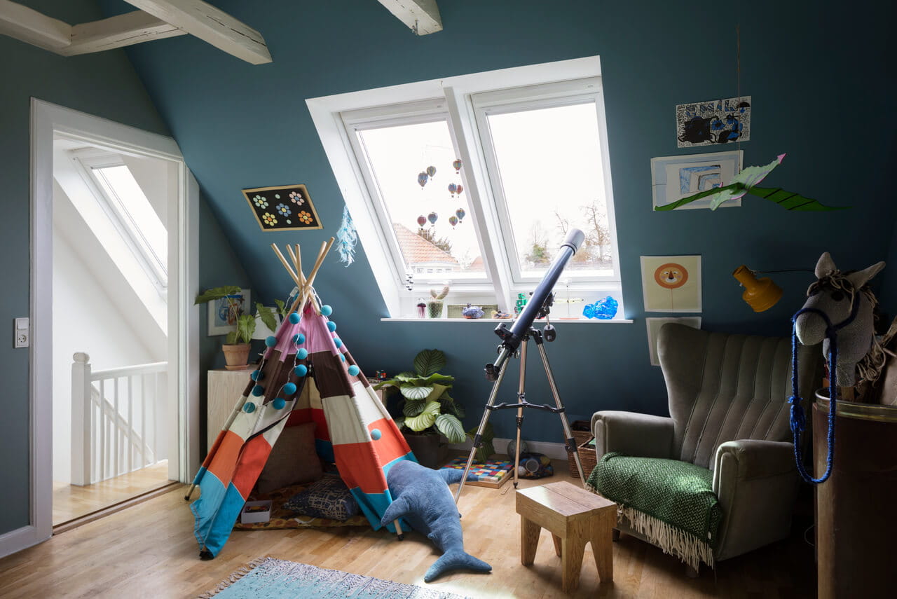 A blue painted kids room in the attic with 2 roof windows