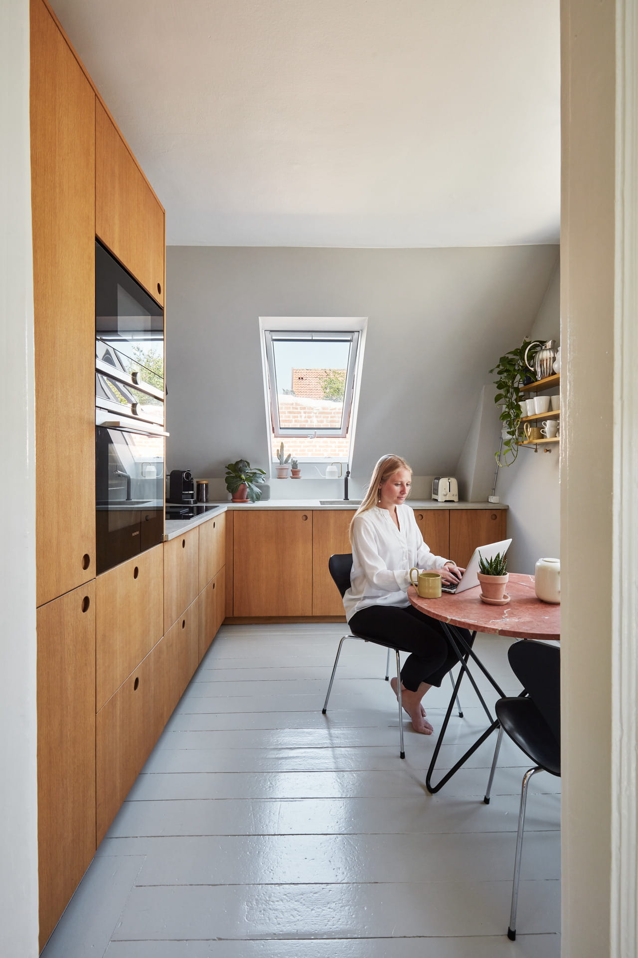 Woman sitting by the table in the kitchen.