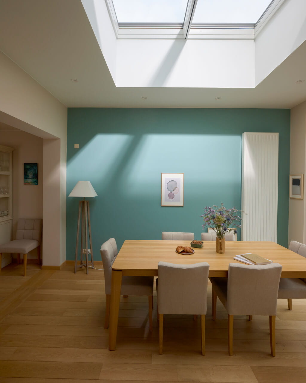 Dining room area with a sun coming in through the flat roof window.