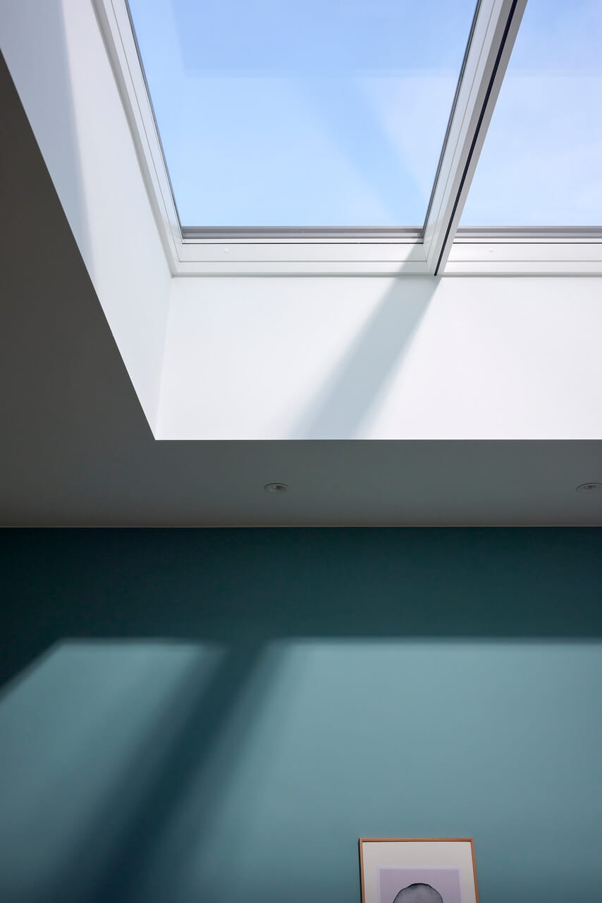 Image of a corner of a flat roof window and the sky visible through it.