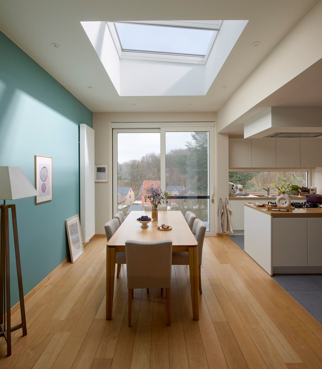 A sunny dining room with flat roof window above the table.
