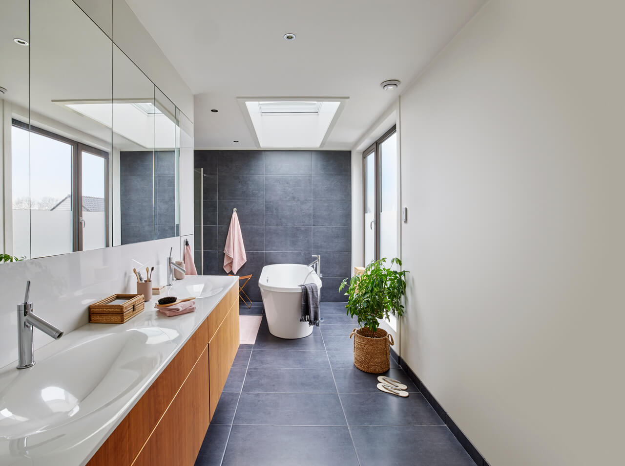 A bright bathroom with roof window just above the bathtub.
