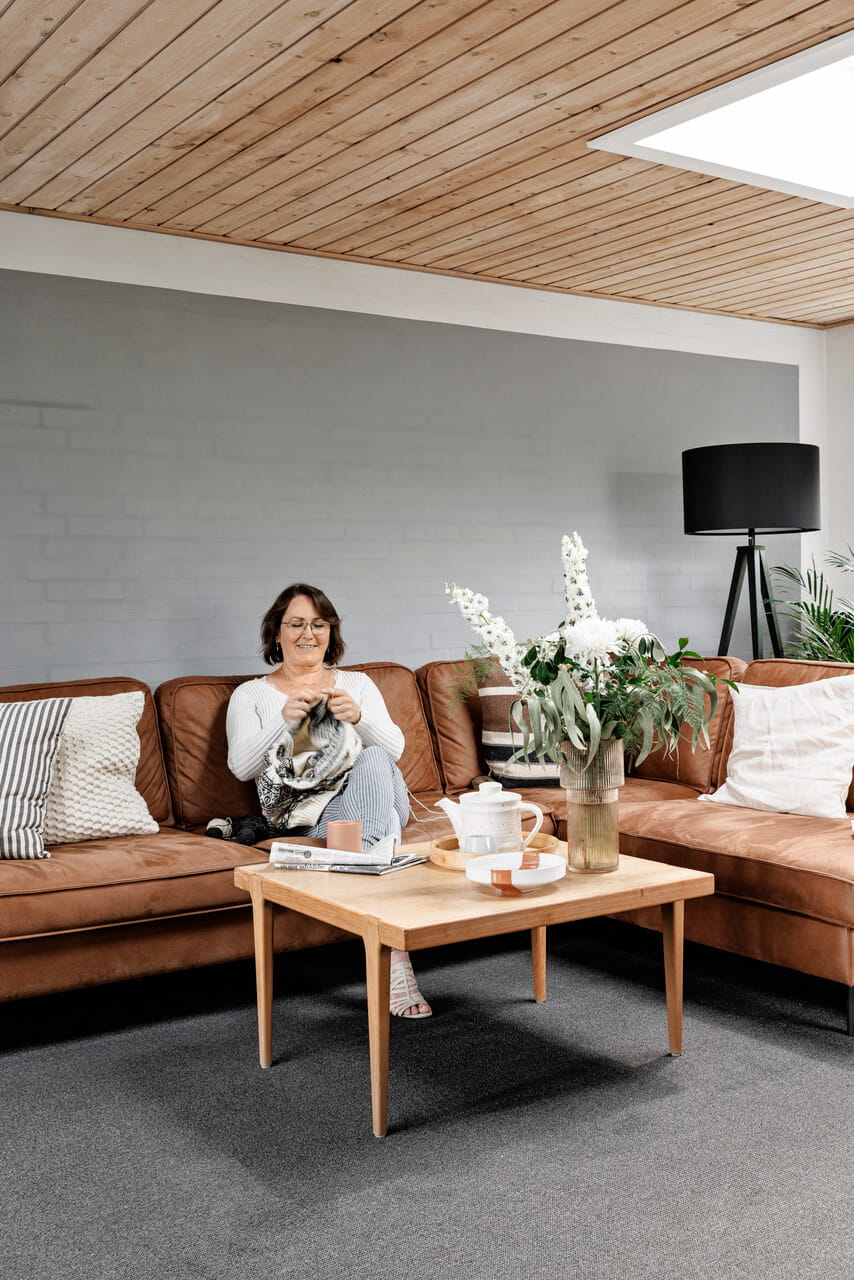 Woman sitting on the leather sofa in the living room.