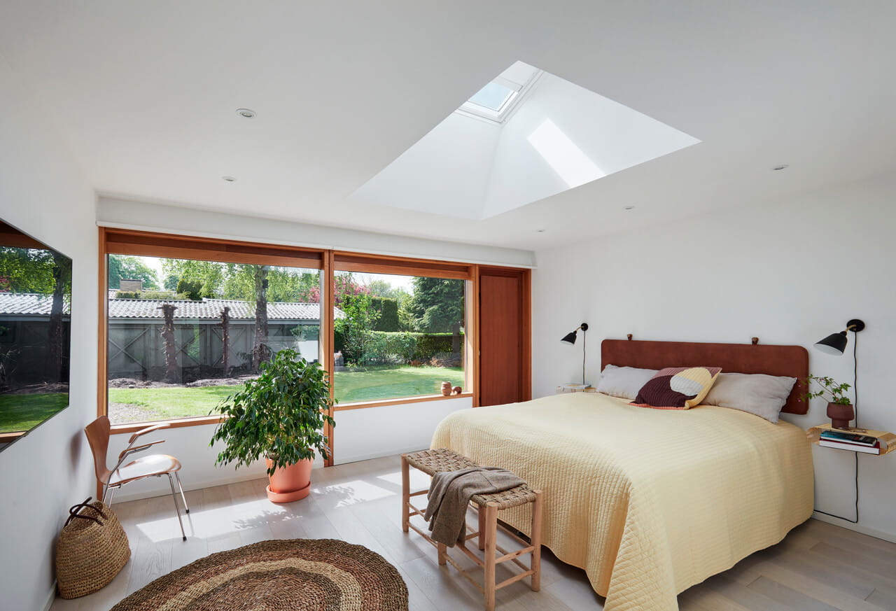 Bright bedroom with large terrace windows and a roof window right above the bed.