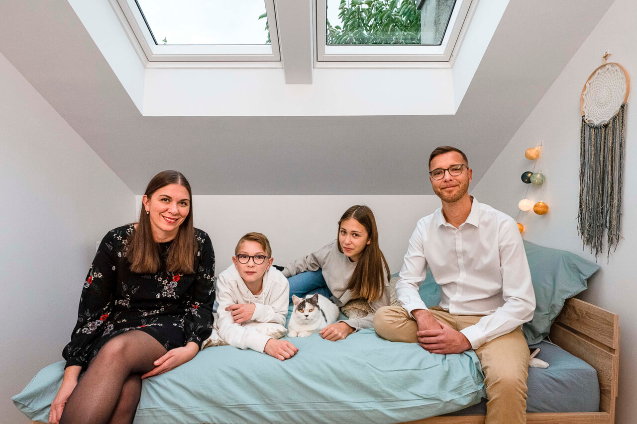 family with two kids posing for a picture on a bedroom bed