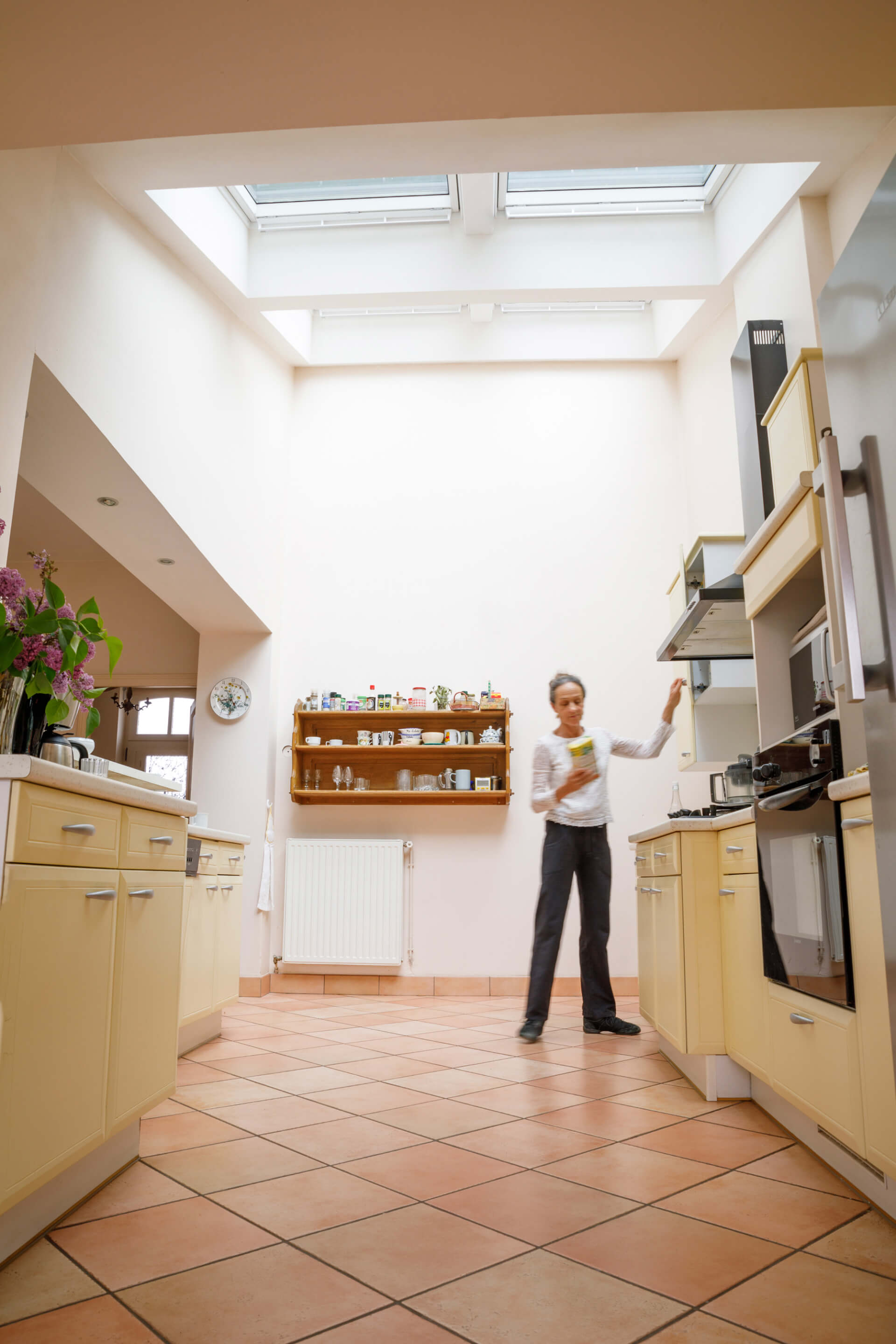 Woman standing in a bright kitchen with roof windows